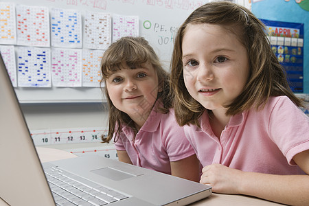 使用笔记本电脑的小女孩教室友谊情谊青少年班级用户通讯硬件小学女性图片