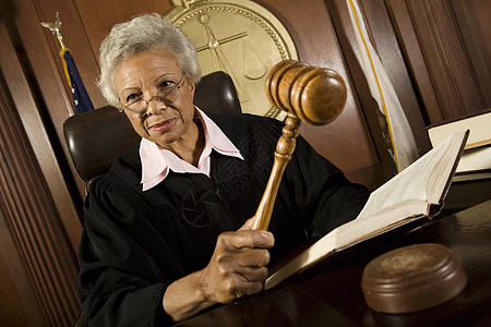 在法庭上使用锤子的女法官法庭室中年头发起诉命令妇女权威制服眼镜法律图片