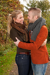 在阳光明媚的秋天夫妻恋爱幸福女士乐趣男人恋人公园微笑金发图片