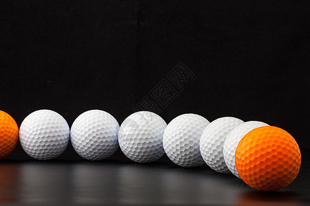 黑色背景的高尔夫球白色橙子桌子材料木头圆圈运动图片