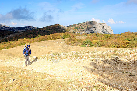 带背包的旅游客去山上女士天空活动游客蓝色岩石爬坡旅行女性远足者图片