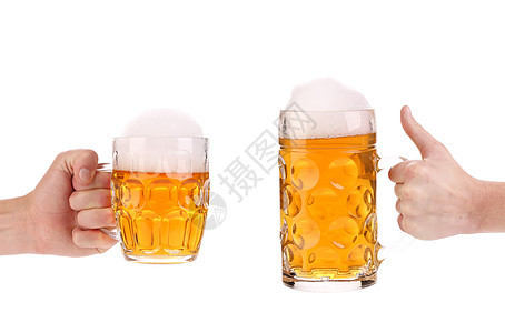 手里拿着两个满杯啤酒的杯子庆典饮料食物泡沫流动液体琥珀色白色黄色派对图片