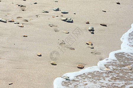 石头之间沙滩上的脚印脚步声冲浪海洋海岸线海岸海浪支撑波浪海滨图片