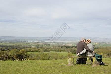 一对夫妇坐在公园的座椅上座位远足者背包全身闲暇摄影休闲空闲生活家具图片