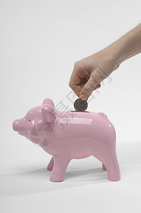 将钱存入猪银行影棚计划经济工作室货币开支一部分硬币摄影金融图片