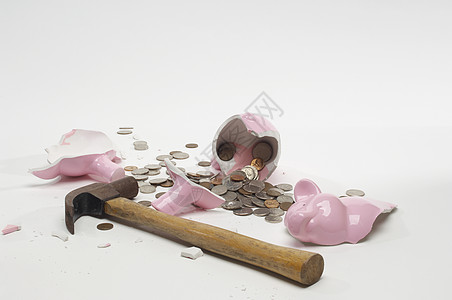 金钱诱惑白底带铁锤和硬币的破碎小猪库背景