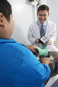 友善的医生准备检查男孩的血压图片