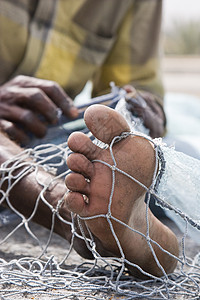 当地渔民修补他在Fujairah网中的洞和绳子渔业身体视图男人生活一部分修复特写方式渔夫图片