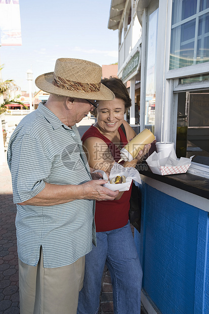 在食品摊点购买热狗的老年夫妇幸福夫妻男士退休食物微笑假期个人图片
