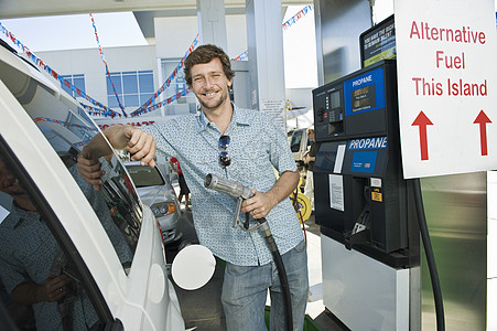在天然气加油站加油的汽车加油时微笑的人的肖像图片