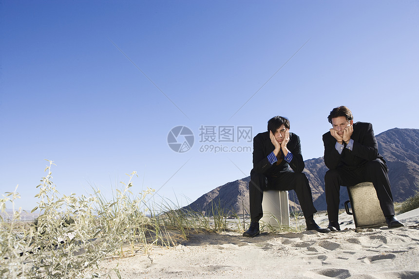 两位商务人士坐在沙漠的案情摘要上图片