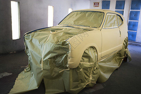 车库中一辆新油漆汽车的景象车辆生产黄色磁带外套面具水平引擎盖身体喷漆图片