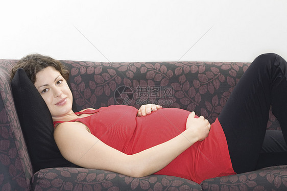 孕妇在沙发肖像上放松长椅人类母性眼神肚子服装成人人生棕色女士图片