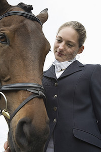 在户外骑马的女性骑马者工作夹克团结动物一人女孩视图友谊低角度图片