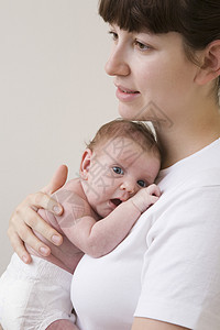 母亲拥抱新生婴儿工作室的肖像拍摄孩子视图成年头肩影棚漏洞宝贝男孩关爱女婴图片