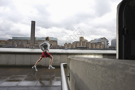人类在泰晤士河上慢跑 在幕后与现代塔特一起男子跑步训练服装城市赛跑者场景多云生活方式成年图片