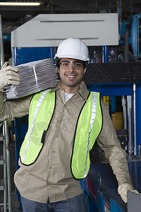 一名微笑着的工业经营者在工厂中携带报纸的肖像制造业拉丁手套工作工作服衣服生产男人职业印刷图片