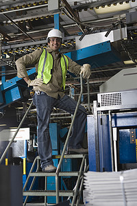 工作时微笑着的工业机器操作员的肖像图片