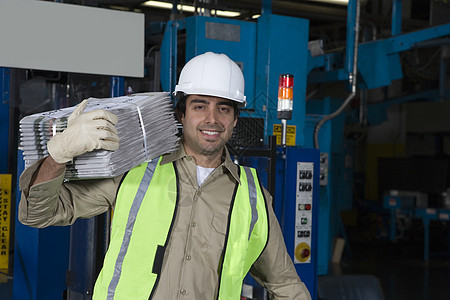 一名微笑着的工业经营者在工厂中携带报纸的肖像男人生产印刷拉丁水平安全帽制造业职业机械起重图片
