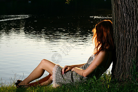 女孩坐在森林河岸上的女孩乡村女士草地假期国家娱乐成人银行农村女性图片