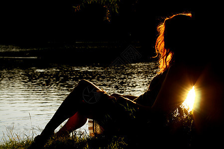女孩坐在森林河岸上的女孩女士农村草地假期娱乐国家乡村树木女性银行图片