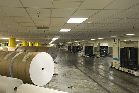 在宽敞的报纸工厂里看到一卷巨大的纸张水平出版命令生产棕色材料地面工业职场造纸图片
