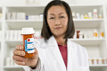 一名持有处方药的女性药剂师的肖像图片