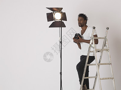 成人中年3035岁摄影演播室摄影师影棚梯子防雷设备沉思创造力裁剪男子图片