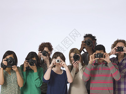 一群年轻人在摄影工作室拍摄的镜头上直接拍照片图片