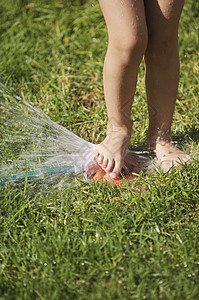 南非开普敦女孩玩草坪喷洒灭水机图片