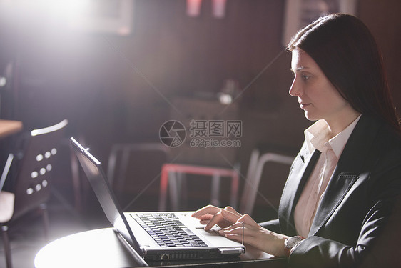 在咖啡馆使用笔记本电脑的女商务人士商务人士专注成年长发咖啡店休闲衣冠桌子头发图片