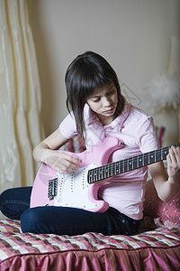 年少女孩玩电吉他女孩专注演奏闲暇吉他外表青春期黑发乐器粉色图片
