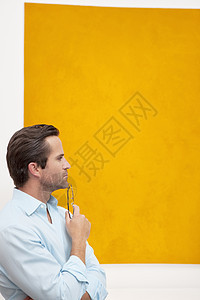 在墙壁绘画前 一位深思熟虑的年轻人的近视图片