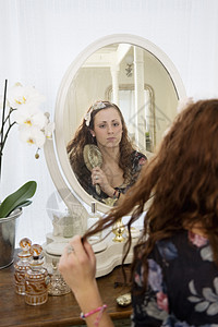 年轻女人在镜子前梳头发的女青年图片