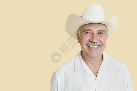 穿着黄底牛仔帽的快乐老年男子的长相肖像背景男士成人帽子彩色衬衫幸福黄色头肩闲暇图片