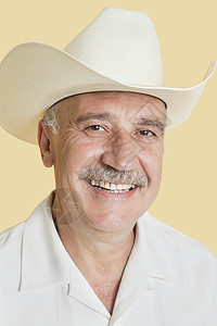 穿着黄底牛仔帽的快乐老年男子的长相肖像衬衫微笑幸福帽子男性男士成人影棚头肩黄色图片