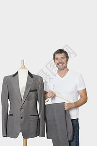 成熟男人的肖像 站在缝制假人旁边 灰色背景图片