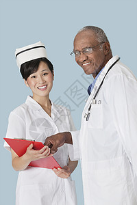 浅蓝色背景下讨论医疗报告的快乐医疗专业人员的肖像图片