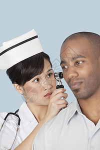 护士检查男性病人耳朵轻蓝底浅蓝色背景的耳部程序治疗测试从业者药物治疗亚裔彩色专注卫生职业图片