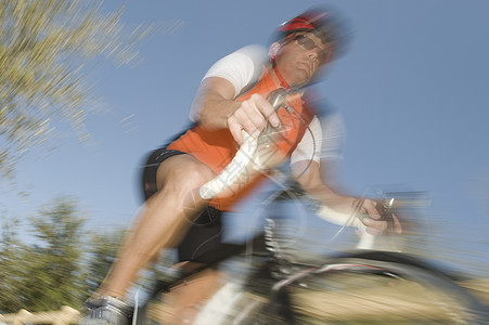 男性骑自行车的模糊运动蓝天防护短裤头饰骑行男人成人肾上腺素车把行动图片