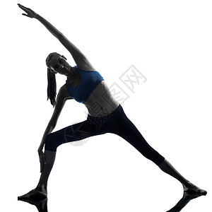 女人锻炼伸展三角形 形成瑜伽的轮廓图片