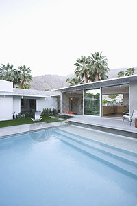 游泳池和现代家庭外表的视野建筑蓝色平房脚步游泳住宅财产水池泳池棕榈背景图片
