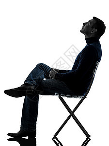 男人坐着看着长长的光影男性椅子成人座位阴影白色成年人休闲装图片
