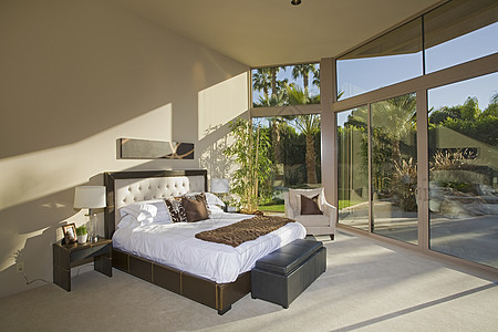 一个宽敞的阳光下卧室和门廊风景的景象房子晴天床头板奢华房间玻璃天花板地面床头脚凳图片