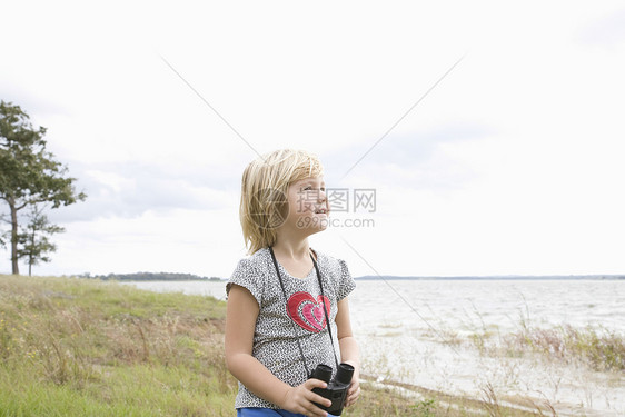 女孩站在湖边的望远镜上图片