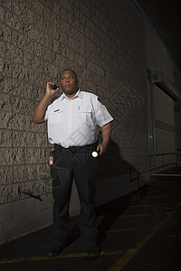 警卫警卫用火炬巡逻衬衫制服成人安全年轻人男人对讲机石墙手电筒图片