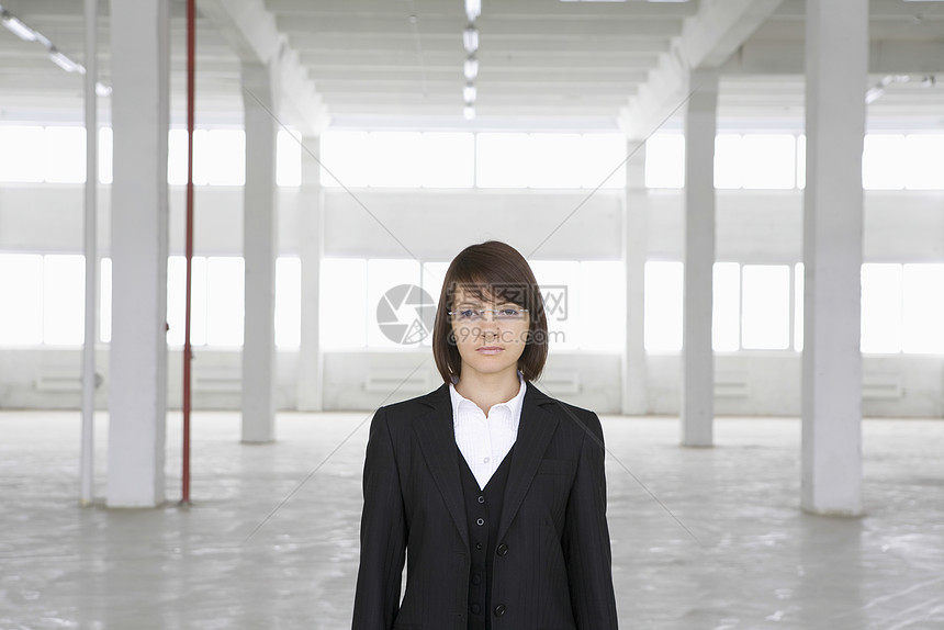 女商务人士在空仓库里站着日光个体收腰自雇人士经营西装女子眼镜外套图片