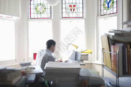 商务人士在海湾窗口的办公桌工作窗户飘窗男子专注办公房间桌子家居学习吊灯图片