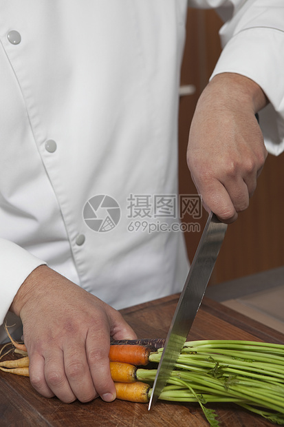 厨师在厨房木板上切胡萝卜的中产男厨师图片