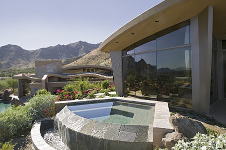 在一个现代房子的外边 一个小池塘和山峰在背景图片